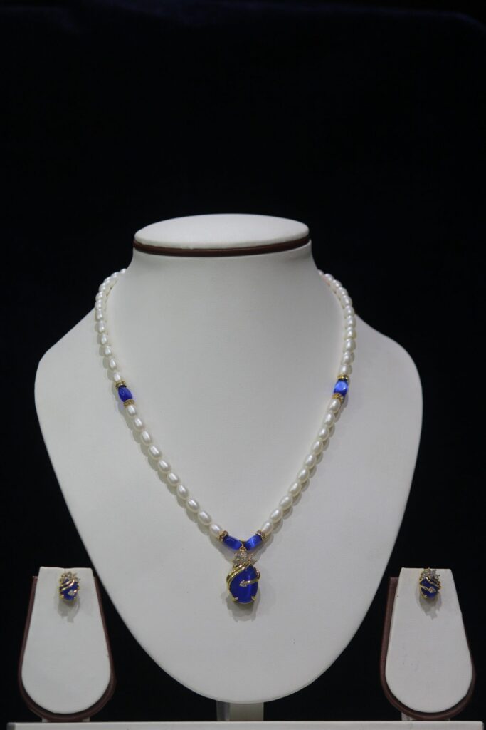 Pearl and Blue Stone Necklace Set - A graceful necklace featuring luminous pearls and radiant blue stone accents, paired with matching earrings for timeless elegance.