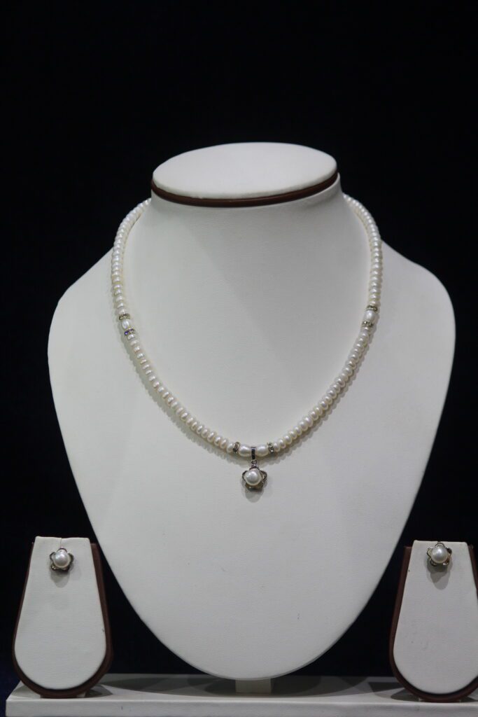 Pearl Necklace Set with Flower Pendant - A stunning necklace featuring lustrous pearls and a delicate flower-shaped pendant, paired with matching earrings for elegance.