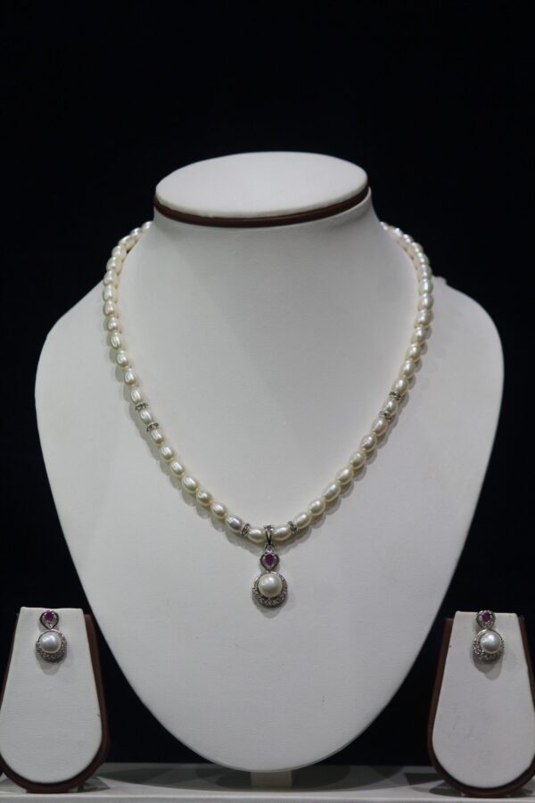Pearl Necklace Set with Ruby Pendant - A luxurious pearl necklace set featuring a stunning ruby pendant for a sophisticated and elegant look.