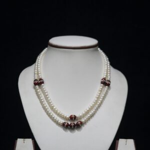 Pearl Necklace Set with Red Stone Accents - A luxurious necklace featuring luminous pearls paired with vibrant red stones, complemented by matching earrings.