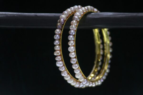 Two-tone pearl bangle set featuring elegant pearls combined with a sleek metallic finish for a sophisticated and modern look.