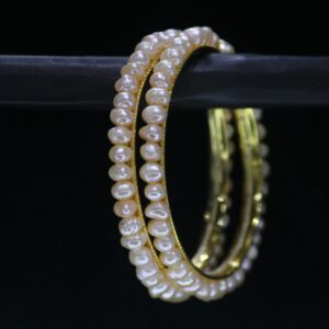 Traditional pearl bangle featuring lustrous pearls on an ornate metallic band, perfect for cultural and festive occasions.