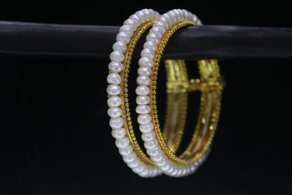 Classical pearl bangle featuring timeless pearls on a sleek metallic band, ideal for traditional and modern occasions.