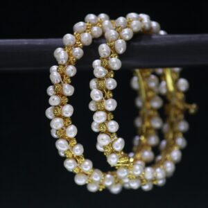 Elegant pearl bangles featuring lustrous pearls set on polished metallic bands, designed to add timeless charm and sophistication to your look.
