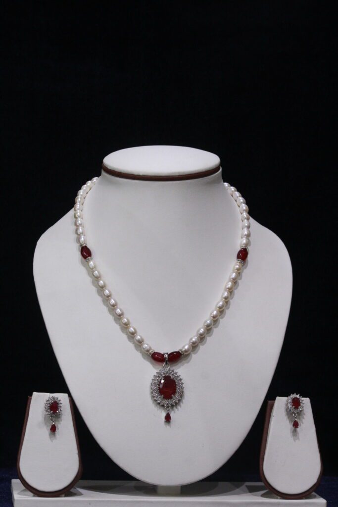Pearl necklace set with a vibrant ruby pendant, featuring lustrous pearls and an exquisite design for timeless sophistication and elegance.