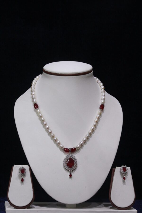 Pearl necklace set with a vibrant ruby pendant, featuring lustrous pearls and an exquisite design for timeless sophistication and elegance.