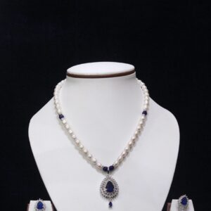 Pearl necklace set with a stunning blue stone pendant, featuring lustrous pearls and an elegant design for a timeless, sophisticated look.