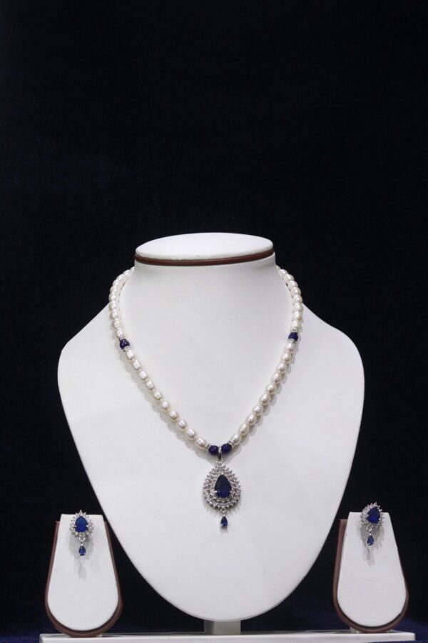 Pearl necklace set with a stunning blue stone pendant, featuring lustrous pearls and an elegant design for a timeless, sophisticated look.