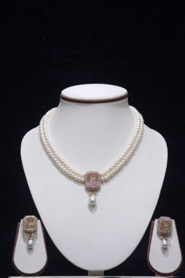 Two-layered pearl necklace set with a stunning pink stone pendant for an elegant look.