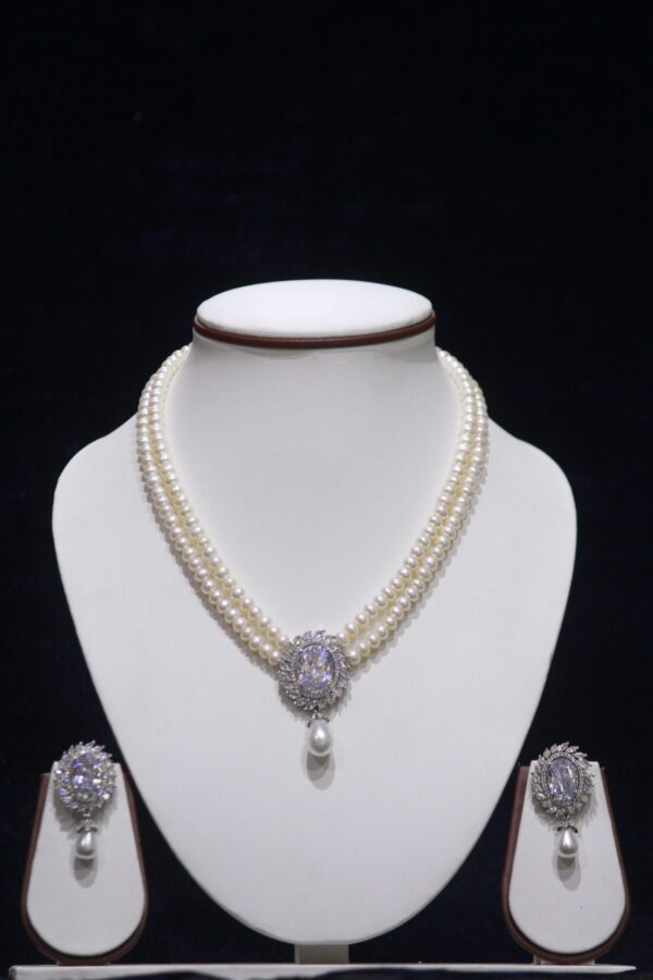 Two-layered pearl necklace set with a white pendant, combining the timeless elegance of pearls with the pure and sophisticated appeal of a white gemstone.