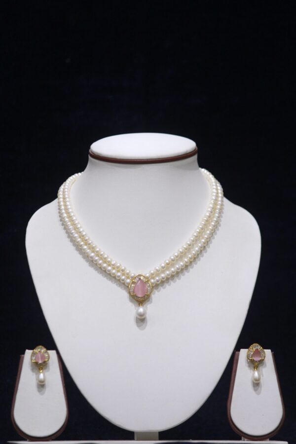 Two-layered pearl necklace set with a pink stone pendant, combining the timeless elegance of pearls with the delicate charm of a pink gemstone.