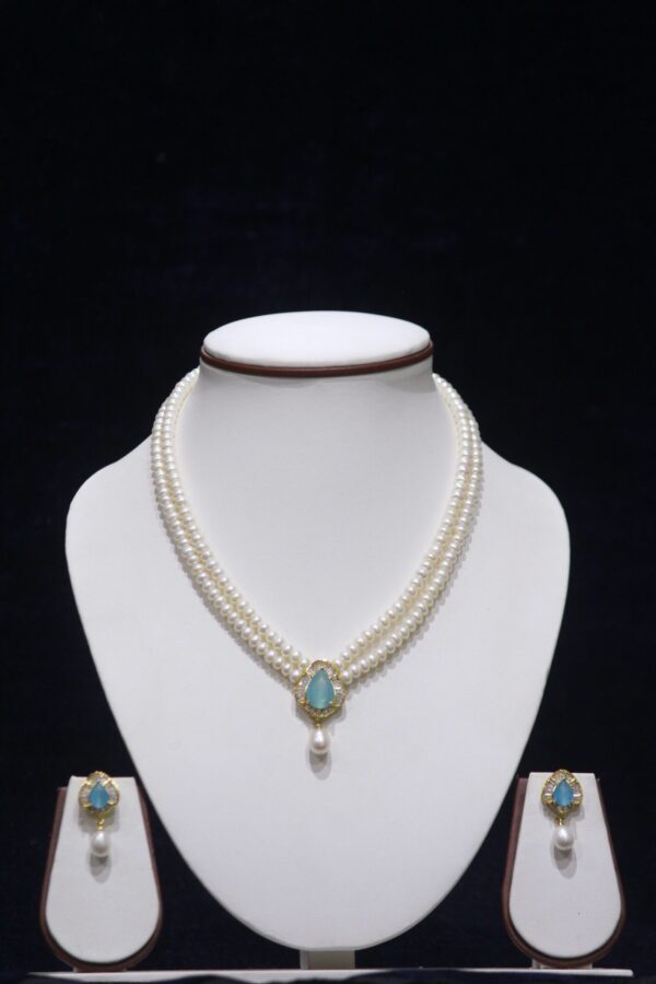 Two-layered pearl necklace set with a sky blue stone pendant, combining the classic elegance of pearls with the serene beauty of a sky blue gemstone.
