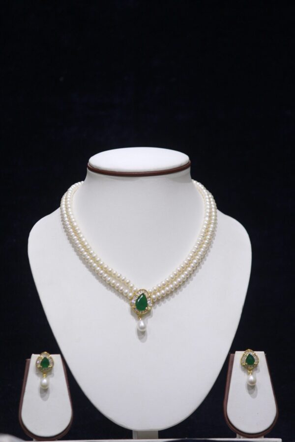 Two-layered pearl necklace set with an emerald pendant, featuring a perfect blend of classic pearls and a luxurious emerald accent.