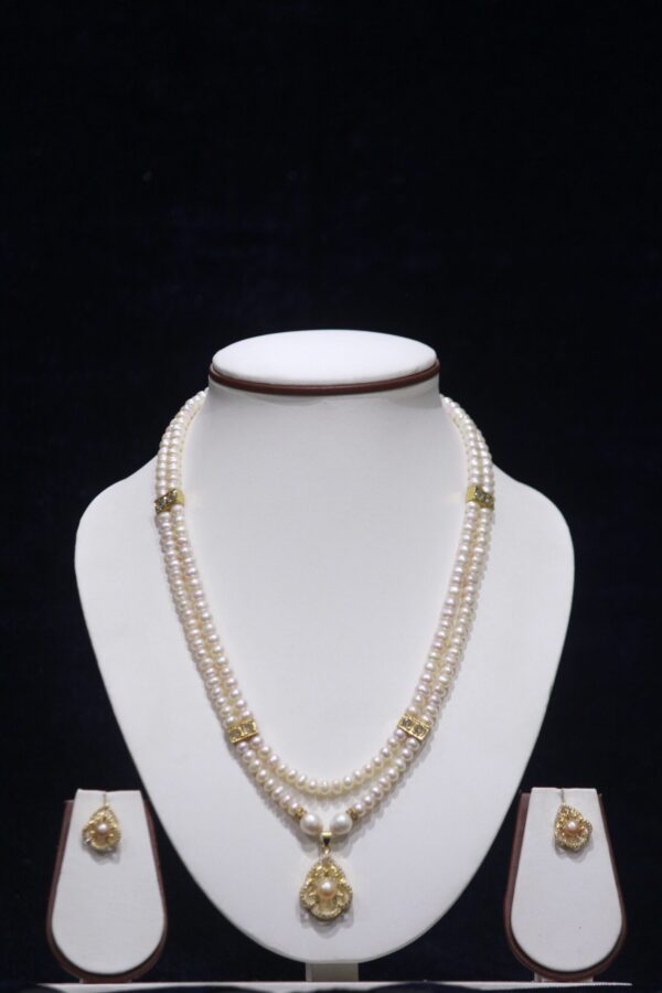 Stunning two-layered pearl necklace set with a beautiful pendant, perfect for adding elegance to any outfit.