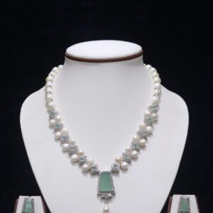 Elegant pearl necklace set featuring a striking green stone pendant, with matching earrings, offering a sophisticated and timeless design.