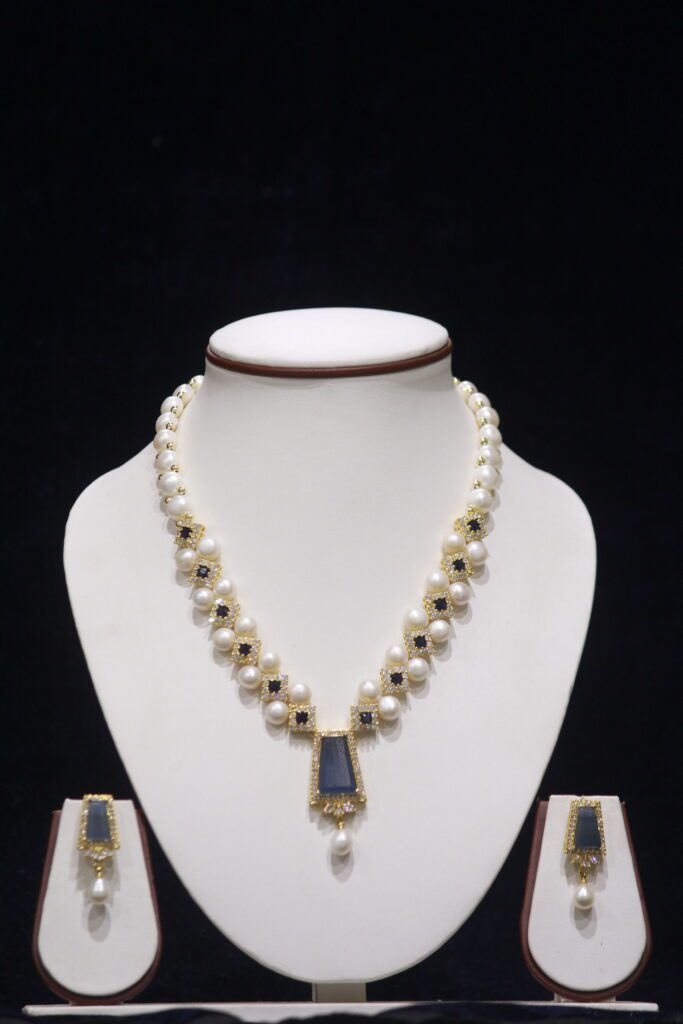 Elegant pearl necklace set with a beautiful blue stone pendant, adding a touch of color and sophistication to any outfit.