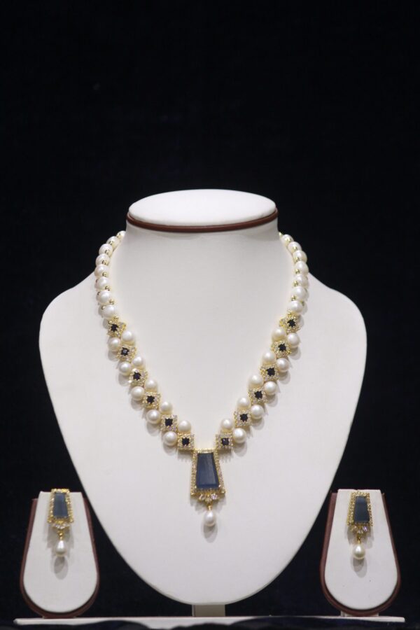 Elegant pearl necklace set with a beautiful blue stone pendant, adding a touch of color and sophistication to any outfit.
