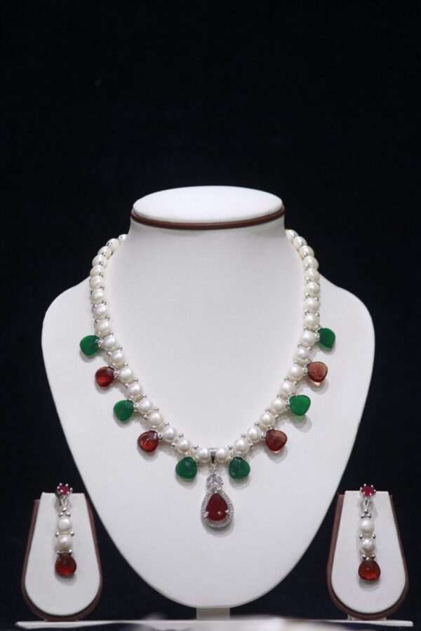 Pearl necklace set with ruby and emerald accents, offering a luxurious and vibrant touch to your jewelry collection.