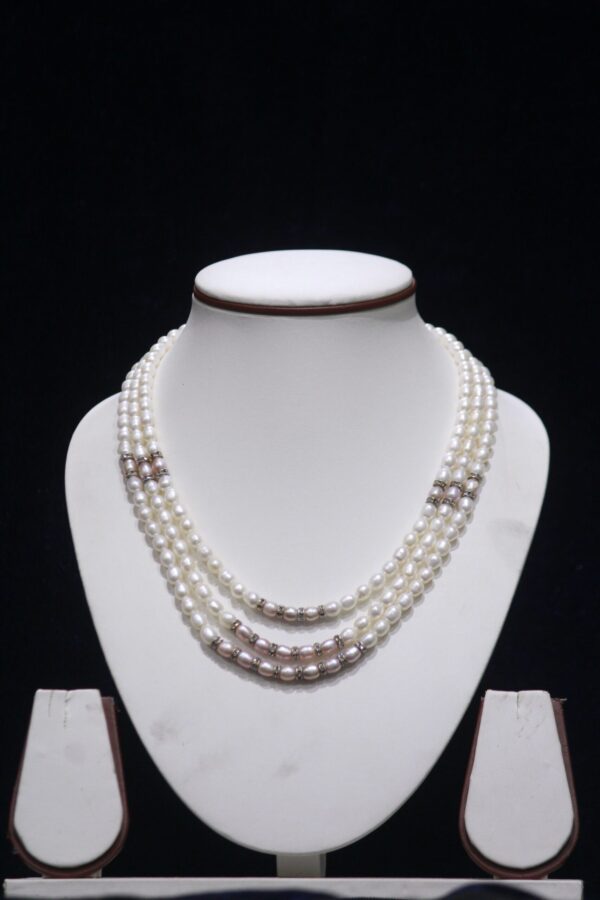 Three layered pearl necklace set with silver accents, offering a luxurious design for special occasions.