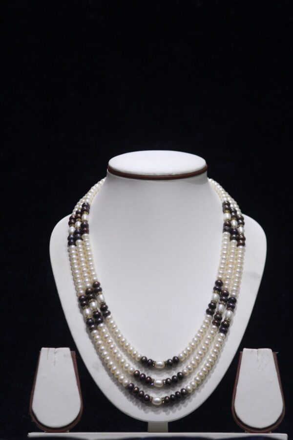 Three-layered two-tone pearl necklace set with a harmonious blend of contrasting colors for a stylish, elegant look.