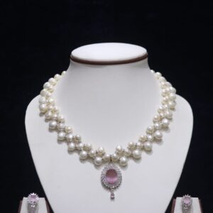 Three-layered pearl necklace set with pink stone pendant, showcasing elegant and vibrant design.