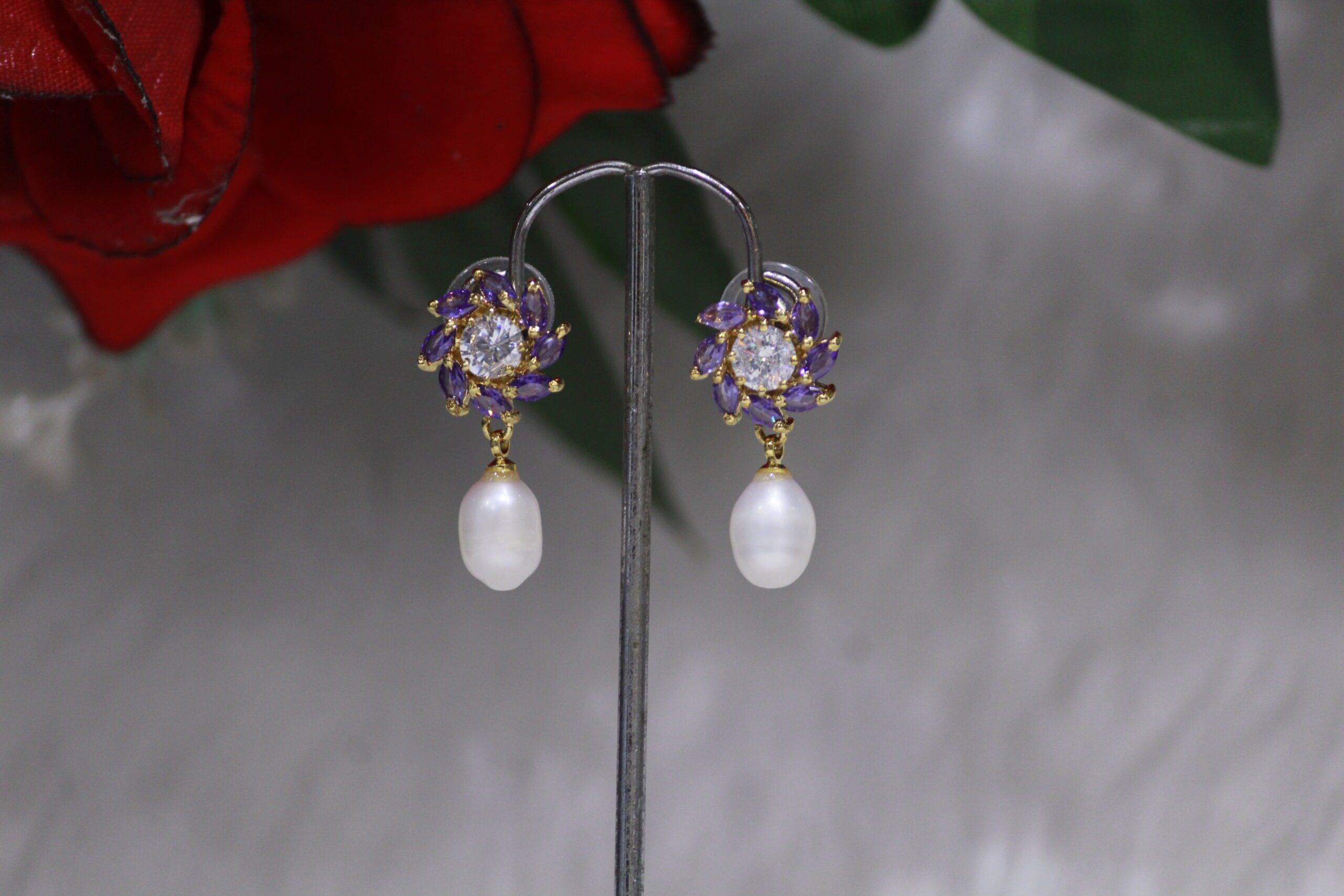 Pearl Drop Earrings with Purple Stone Flower Design - Elegant earrings featuring a radiant pearl drop paired with a vibrant purple stone flower motif.