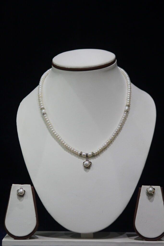 Pearl Necklace Set with Flower Pendant - A stunning necklace featuring lustrous pearls and a delicate flower-shaped pendant, paired with matching earrings for elegance.