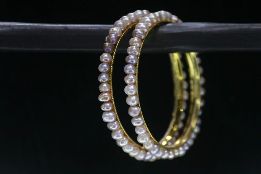 Two-tone pearl bangle set featuring elegant pearls combined with a sleek metallic finish for a sophisticated and modern look.