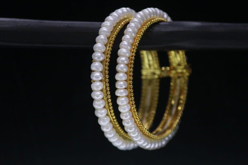 Classical pearl bangle featuring timeless pearls on a sleek metallic band, ideal for traditional and modern occasions.