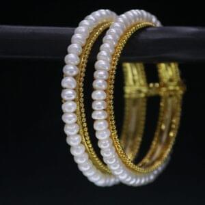 Classical pearl bangle featuring timeless pearls on a sleek metallic band, ideal for traditional and modern occasions.