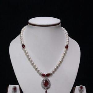 Pearl necklace set with a vibrant ruby pendant, featuring lustrous pearls and an exquisite design for timeless sophistication and elegance.