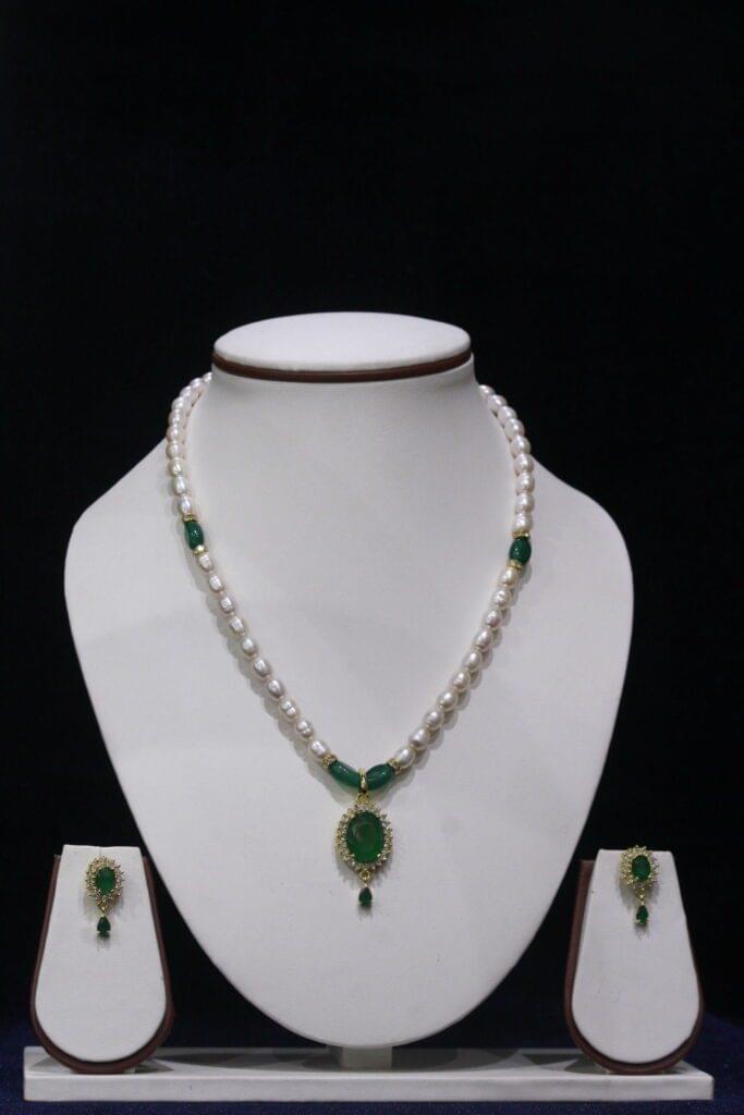 Pearl and Emerald Necklace Set - A luxurious necklace featuring radiant pearls and vivid emerald accents, complete with matching earrings for a refined, elegant look.