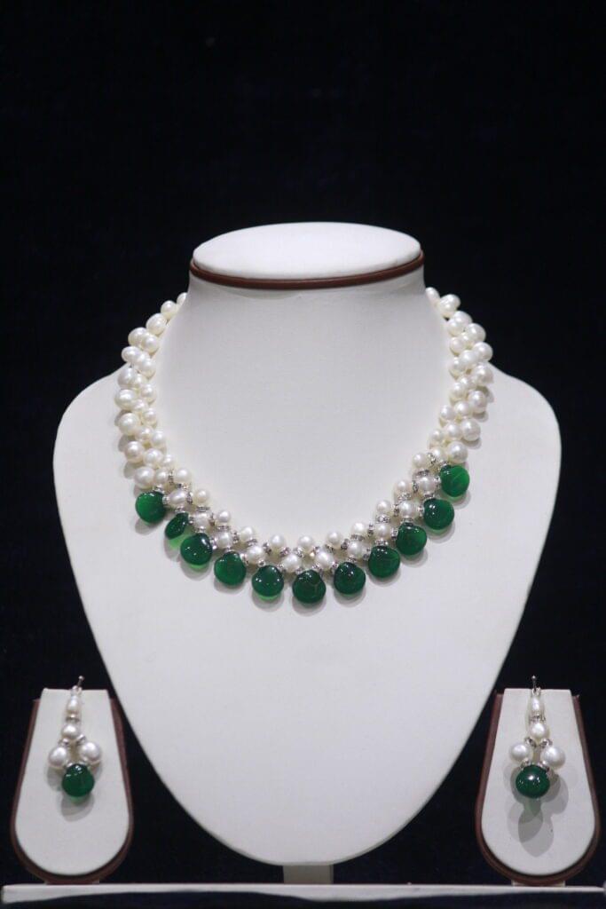 Pearl necklace set with green stone accents for a chic and vibrant look.