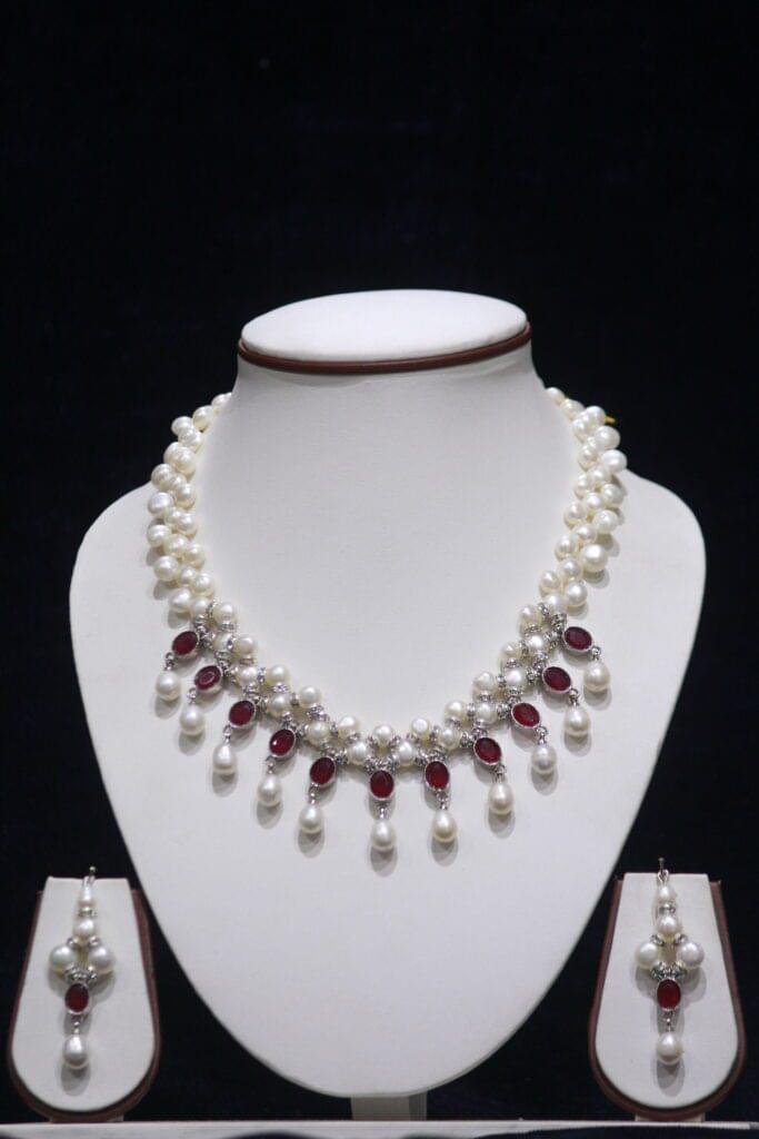 Pearl necklace set with ruby accents for a luxurious and elegant look.