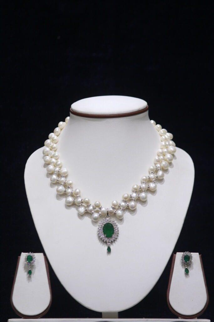 Elegant Pearl Necklace Set with Emerald Pendant, showcasing a timeless design of lustrous pearls and a vibrant green emerald pendant.