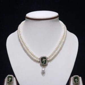 Two-layered pearl necklace set with a green stone pendant, combining the classic elegance of pearls with the vibrant touch of a green gemstone pendant.