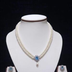 Two-layered pearl necklace set with a blue stone pendant, combining the timeless beauty of pearls and the vibrant elegance of a blue stone.