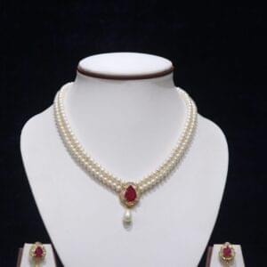 Two-layered pearl necklace set with a ruby pendant, combining classic pearls and a vibrant ruby for timeless elegance.