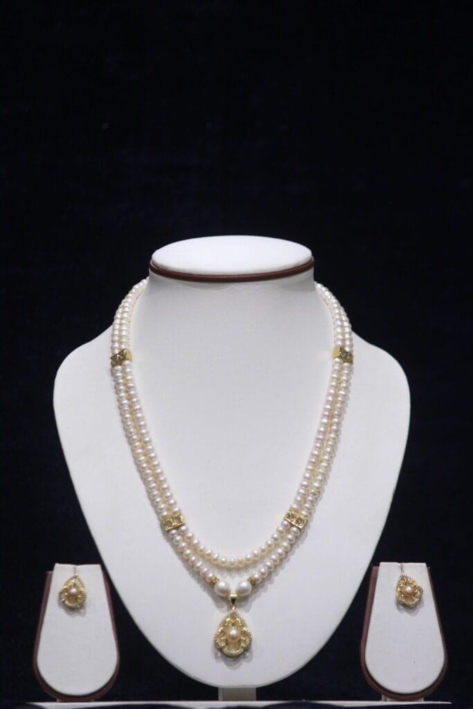 Stunning two-layered pearl necklace set with a beautiful pendant, perfect for adding elegance to any outfit.