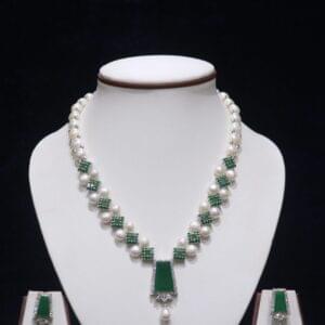 Elegant pearl necklace set with a stunning emerald pendant, perfect for adding a touch of luxury and sophistication to any special occasion.