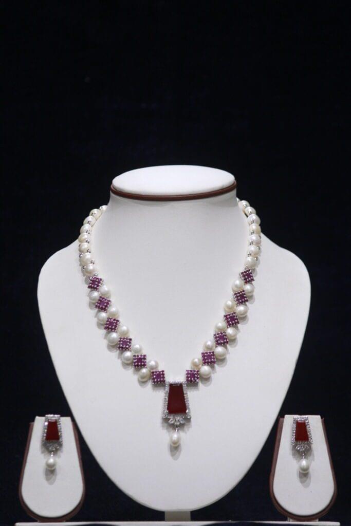 Elegant pearl necklace set with a stunning ruby pendant, perfect for adding a touch of luxury to any occasion.
