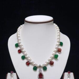 Pearl necklace set with ruby and emerald accents, offering a luxurious and vibrant touch to your jewelry collection.