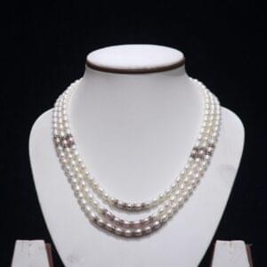 Three layered pearl necklace set with silver accents, offering a luxurious design for special occasions.