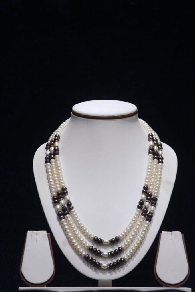 Three-layered two-tone pearl necklace set with a harmonious blend of contrasting colors for a stylish, elegant look.